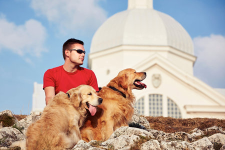 Young man with his dogs (golden retriever).