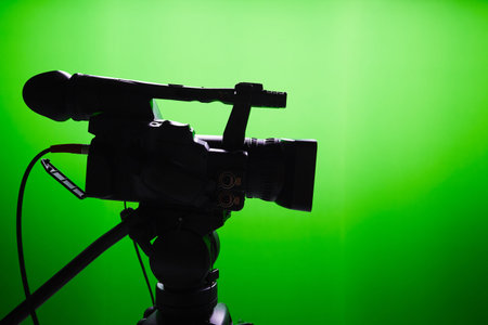 Silhouette of digital video camera in front of the green screenの写真素材
