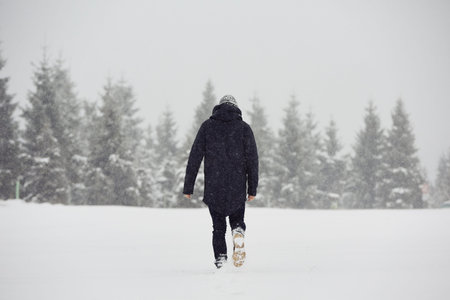 Young man is walking in winter landscapeの写真素材
