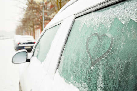 Heart symbol on frozen window of the carの写真素材
