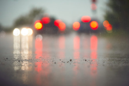 Traffic in rainy day in the city.  View from the level of asphalt level. Selective focus on the wet road.の写真素材
