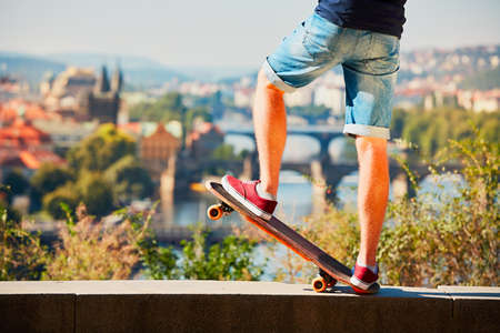 Young skateboarder is riding on the skateboard in the city. Prague, Czech Republic.の写真素材