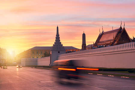 Tuk Tuk taxi in blurred motion in front of Grand Palace during beautiful sunrise  Bangkok, Thailandのeditorial素材