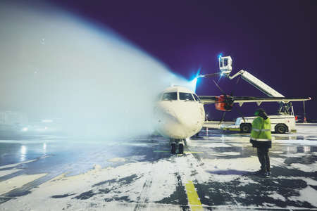 Airport in winter. Deicing of the airplane before flight.の写真素材