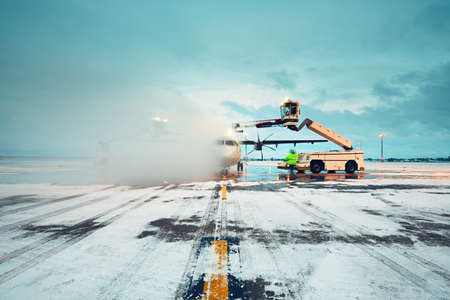 Airport in winter. Deicing of the airplane before flight.の写真素材