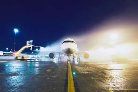 Airport in winter. Deicing of the airplane before flight.の写真素材