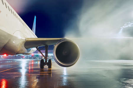 Airport in winter. Deicing of the airplane before flight.の写真素材