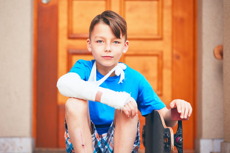 Mischievous boy with broken hand injured after accident on skateboard.