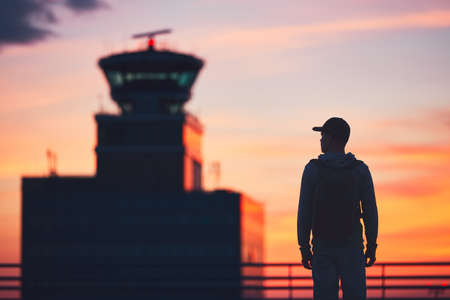 Silhouette of the traveler at the airport. Air Traffic Control Tower at the amazing sunset. Prague, Czech Republic.の写真素材