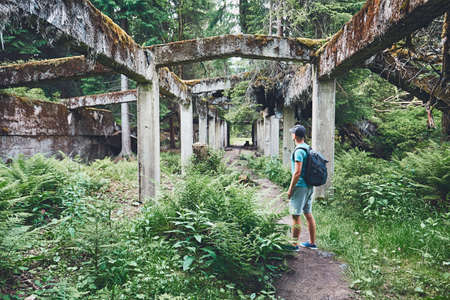 Young explorer inside of the abandoned old ruined factory in the middle of the forest. Ore mountains, Czech Republicの写真素材