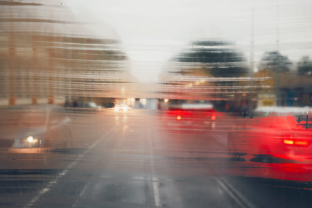 Gloomy day in the city. Street in rain. Selective focus on the raindrops on the window. Prague, Czech Republic.の写真素材