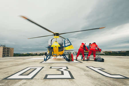 HRADEC KRALOVE, CZECH REPUBLIC - JUNE 17, 2017: Team of the Helicopter Emergency Medical Service passes the patient to the Emergency on the roof University Hospital in Hradec Kralove on June 17, 2017.のeditorial素材