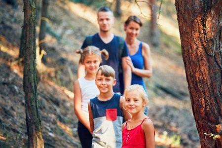 Summertime in the countryside. Family on the trip in forest. Selective focus on the little girl.の写真素材