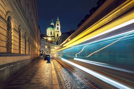 Night traffic on the ancient street near The Church of Saint Nicholas in Prague, Czech Republic.の写真素材