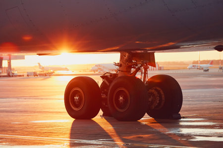 Landing gear of the airplane. Amazing sunset at the airport.