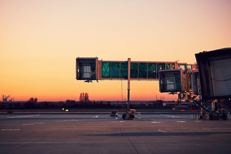 Empty boarding bridges. Airport at the colorful sunset.の写真素材