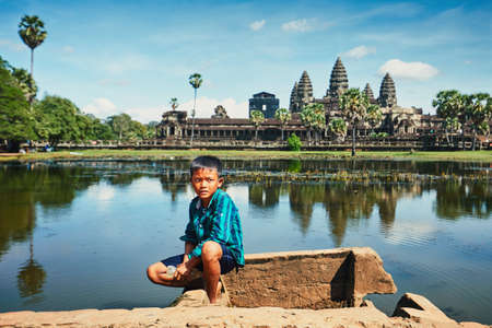Siem Reap, Cambodia - November 10, 2017: Little boy fishing in lake in front of the famous Angkor Wat temple on November 10, 2017 in Cambodia.のeditorial素材