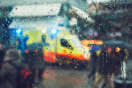 Emergency medical service response in the city. Ambulance cars on the rush street during rain. View...