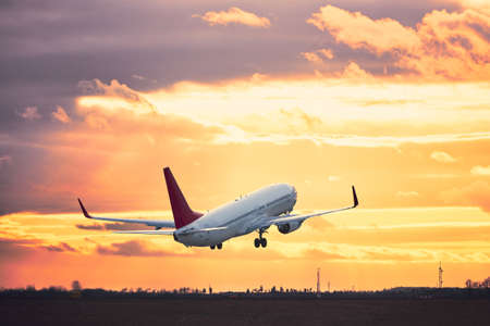 Airplane taking off from the airport runway at the sunset.の写真素材