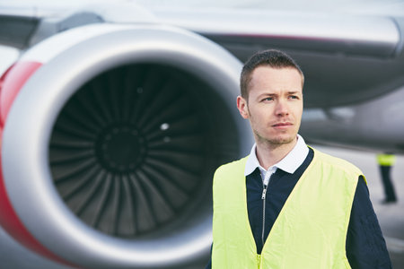 Member ground crew worker at the airport checking airplane before flight.