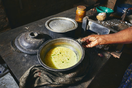 Preparation rice and curry meal. Woman preparing food in traditional home kitchen in Sri Lanka.の写真素材