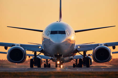 Airplanes in row taxiing to runway for take off. Traffic at airpot at sunset.の写真素材