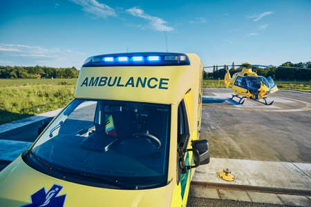Ambulance car against helicopter of emergency medical service. Themes rescue, help and hope.の写真素材