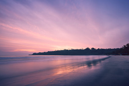 Empty sand beach against coast at amazing sunrise. Tangalle, Sri Lanka.