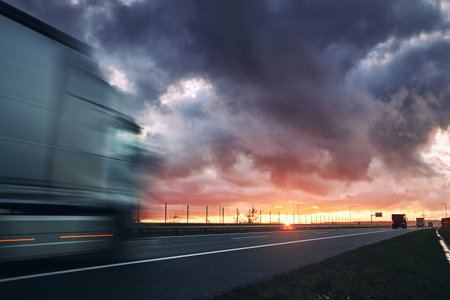 Blurred motion of truck. Traffic on highway at sunset.