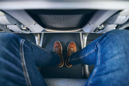 Legroom between seats in commercial airplane. Personal perspective of passenger on leg in economy class.の写真素材