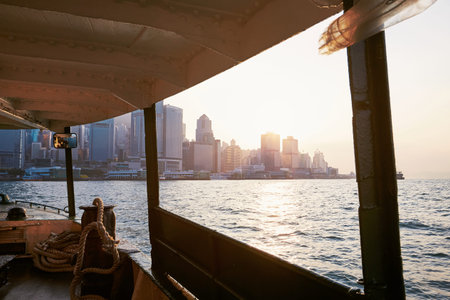 Cityscape with skyscrapers in Hong Kong. View from ferry on modern city at beautiful sunset.