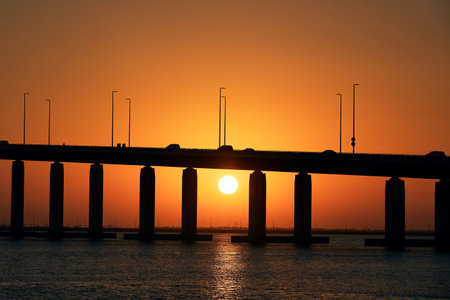 Silhouette of bridge over sea against beautiful sunset. Abu Dhabi, United Arab Emirates