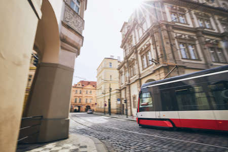 Daily life in city. Modern tram of public transportation in blurred motion. Prague, Czech Republic.の写真素材