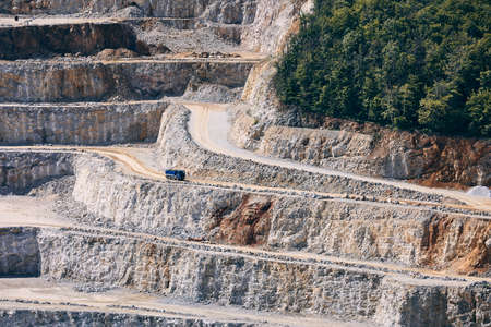 Industrial stone mining. Truck in the middle of huge quarry. の写真素材