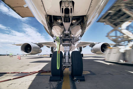 Close-up view of landing gear. Loading of cargo to airplane before flight.の写真素材
