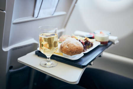 Airline meal and beverage served on seat tables during flight.の写真素材