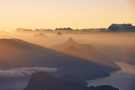Scenic view of lake and mountains against moody sky during beautiful sunrise. Lucerne, Switzerland.