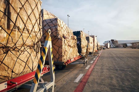 Loading of cargo containers to airplane at airport.の写真素材