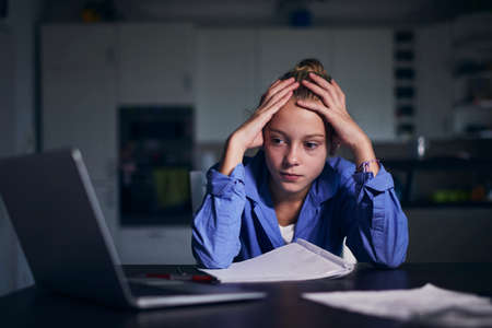 Online school lesson. Schoolgirl learning via internet with laptop at home.の写真素材