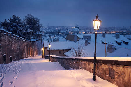 Cityscape of Prague in winter. Snow covered staircase âagainst Lesser Town early morning.の写真素材