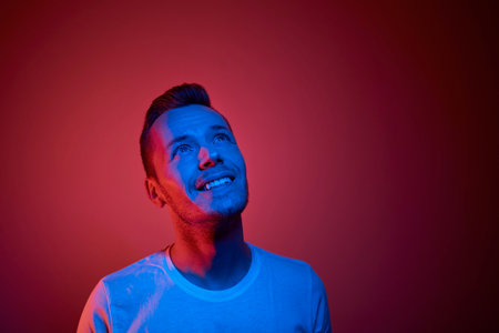 Portrait illuminated of neon lighting. Successful and determined young man.の写真素材
