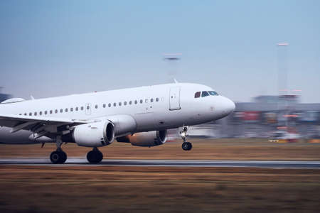 Airplane during landing on airport runway at night. Plane in blurred motion.の写真素材