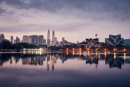 Urban skyline of Kuala Lumpur at dawn. Reflection of skyscrapers in the water surface.の写真素材