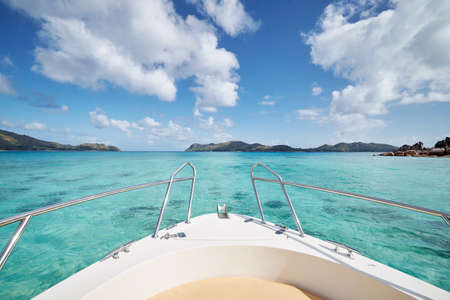 Bow of ship at sea with turquoise water between tropical islands on sunny day. Praslin Island, Seychellesの写真素材