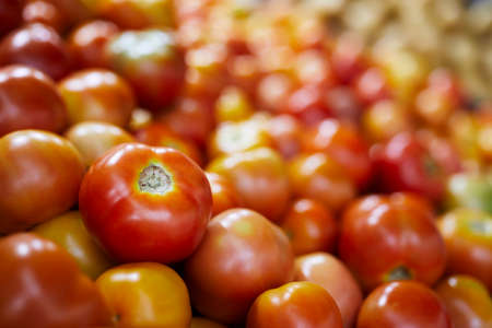 Selective focus on red tomato. Sale of fresh raw vegetable in market stall.の写真素材