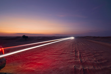 Light trails of car on desert road in the middle sand dunes. Abu Dhabi, United Arab Emiratesの写真素材