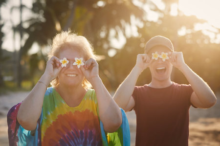 Funny portrait of happy senior woman with her adult son during travel in tropical destination.の写真素材