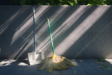 Tools for garden cleaning. Broom and scoop leaning against wall.の写真素材