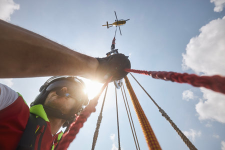 Trutnov, Czech Republic - June 22, 2023: Training of rescue in difficult to access terrain. Doctor of Helicopter Emergency Medical Service hanging on rope under helicopter.のeditorial素材