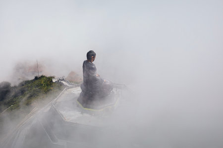 Bronze Buddha statue statue on top of Fansipan mountain peak in mysterious fog. Lao Cai Province, Vietnamの写真素材